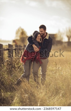 Young couple having a stroll on a grassland in the countryside Royalty-Free Stock Photo #2368597147