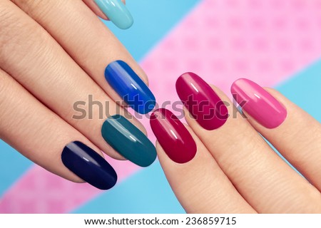 Blue pink nail Polish on long nails on a colored background. Royalty-Free Stock Photo #236859715