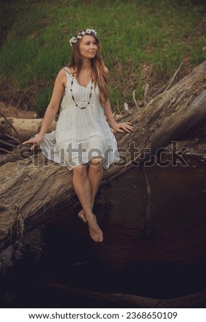 Beautiful Fashion Model Smiling in Forest Portrait. Young adult woman with blond hair wearing a fashionable dress in forest.
