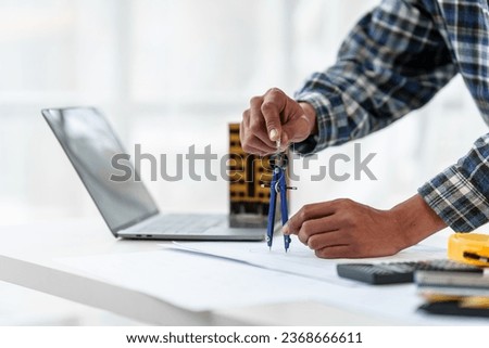 Architect engineer drawing plan blueprint of condominium or apartment tower building Royalty-Free Stock Photo #2368666611