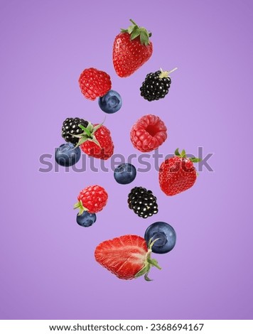 Many different fresh berries falling on orchid color background Royalty-Free Stock Photo #2368694167