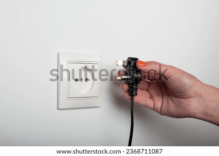 Different standards for electrical outlets. Unsuitable connector and plug in the hand of a person. Incompatibility, concept Royalty-Free Stock Photo #2368711087