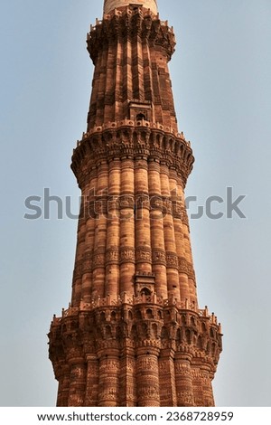 Close up view of Qutb Minar minaret tower part Qutb complex in South Delhi, India, big red sandstone minaret tower landmark popular touristic spot, Exterior Arabic text about history and Islamic faith Royalty-Free Stock Photo #2368728959