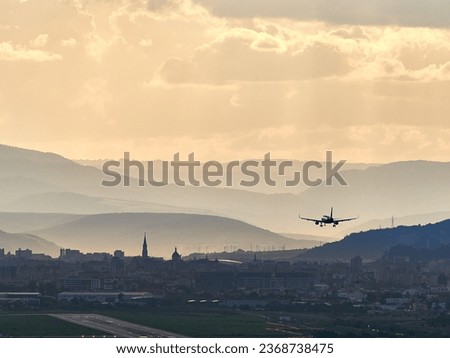 Dramatic sunlight over the city. Avram Iancu airport runway in Cluj with plane landing. East side view of Cluj Napoca, Romania. Passenger plane is landing during a wonderful sunset. Royalty-Free Stock Photo #2368738475