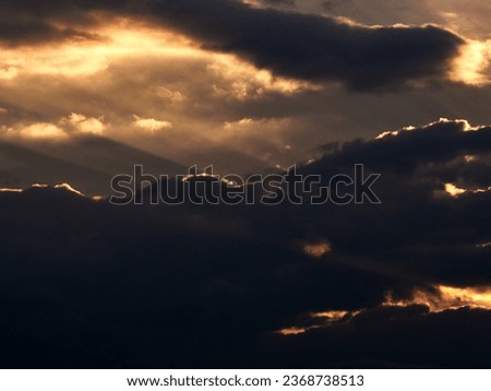 End of the day concept. Beautiful clouds after sunset. Sunset Sky on Twilight in the Evening with Orange Gold Clouds. Ray lights on a dramatic sky at sunset. Royalty-Free Stock Photo #2368738513