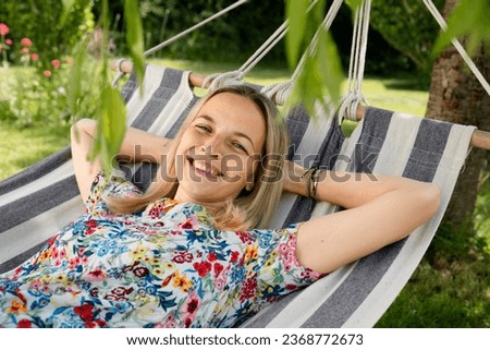 beautiful, blond young woman is relaxing in hammock in garden Royalty-Free Stock Photo #2368772673
