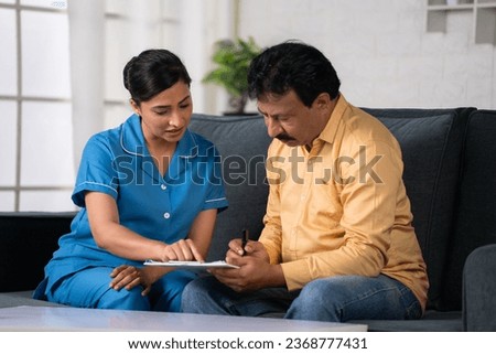 Indian nurse helping recovered patient to fill up hospital medical documents at home - concept of insurance policy, Guidance and Medical Assistance