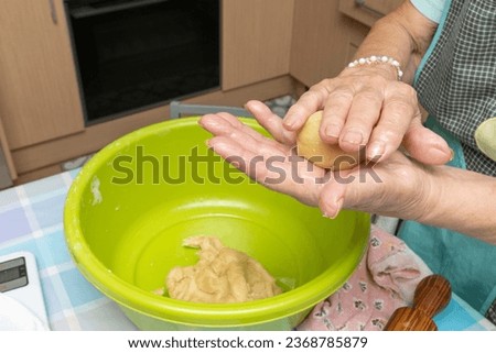 Hands of an adult woman kneading a ball of flour to prepare Cocarrois, typical empanadas from Mallorca, made with flour and vegetables