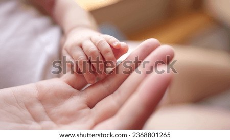 mother holding baby newborn hand. friendly family kid dream concept. mothers day concept. baby newborn in mother lifestyle arms close-up hand Royalty-Free Stock Photo #2368801265