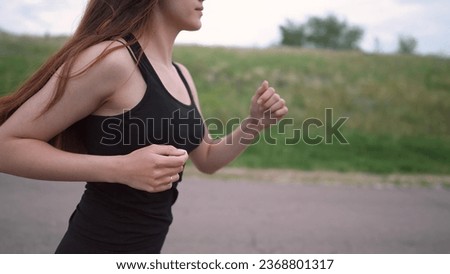 a free girl runs in morning along the asphalt road. doing sports lifestyle healthy concept. pretty girl running on asphalt training outdoors. girl losing weight running