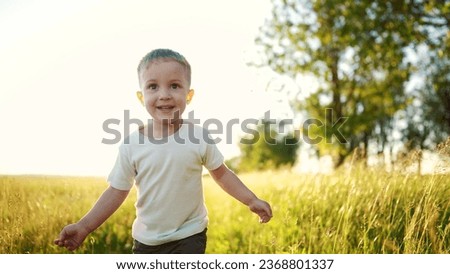 boy child running in nature in the park. happy family kid dream concept. free child son runs along rural road next to a field in nature. free baby runs and plays in the park sun