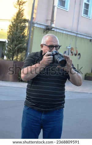 Portrait of a male reporter photographer with a camera in his hands