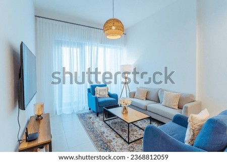 A serene and clutter-free living room bathed in natural light, featuring clean lines, neutral tones, and tasteful decor elements. Royalty-Free Stock Photo #2368812059