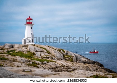 Iconic Peggy's Cove Lighthouse with red fisherman boat, Nova Scotia, Canada. Photo taken in September 2023.