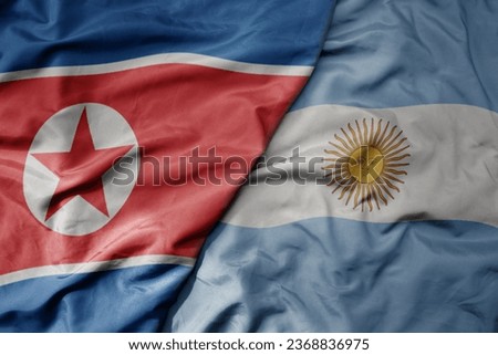 big waving realistic national colorful flag of north korea and national flag of argentina . macro