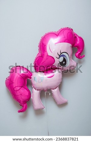 pink toy pony balloon on white background
