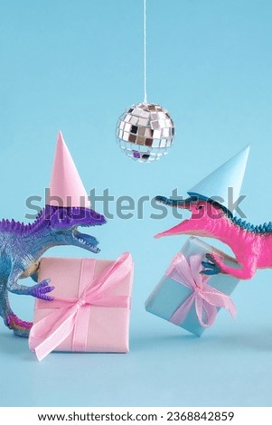 Cute blue and pink dinosaurs wearing party hat and holding present box on blue background.