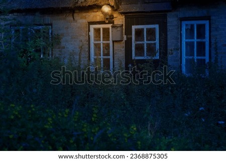 Amid the desolation of an old, abandoned workers' dwelling, a lonely lamp flickers, illuminating the eerie, forgotten past. Royalty-Free Stock Photo #2368875305