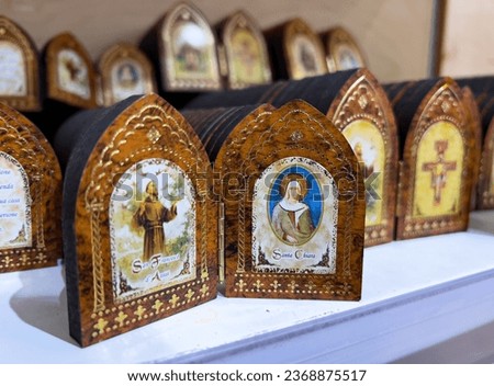 A wooden booklet with picture of Saint Francis and Saint Clare of Assisi on the shelf in souvenir shop