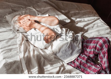 Unhappy elderly woman lying in bed at home thinking pondering over life problems, mourning or yearning, upset sad senior female relax in bedroom feel unwell or stressed suffering from insomnia Royalty-Free Stock Photo #2368887371