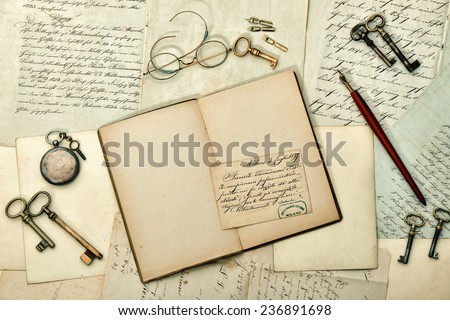open book, vintage accessories, old letters and postcards. nostalgic aged paper background. retro style toned picture