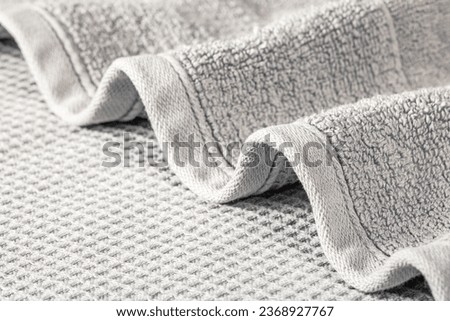 Soft terry towel folded in waves on a gray background close-up. Royalty-Free Stock Photo #2368927767