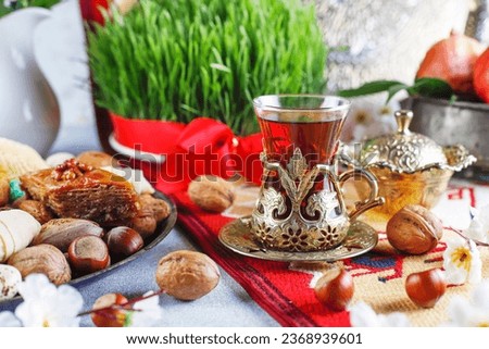 Traditional Azerbaijan holiday Novruz background with green semeni,traditional azerbaijan sweets,shekerbura,qogal,paxlava,mutaki and different nuts and sweets,top view,space for copy.