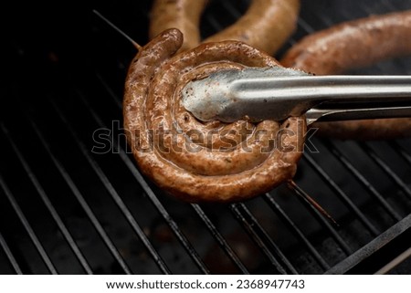 Sausage and barbecue. Grilled sausages on the grill, close-up. Close up picture of spiral pork sausage grilled on barbeque 