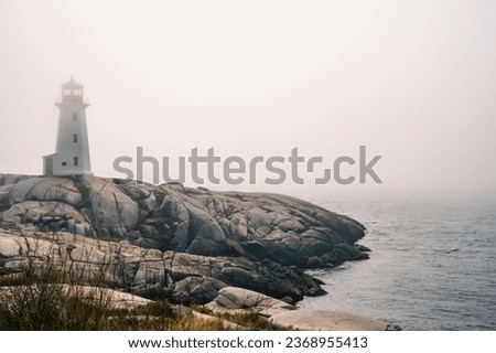 Iconic Peggy's Cove Lighthouse on a foggy day, Atlantic Ocean, Nova Scotia, Canada. Photo taken in September 2023.