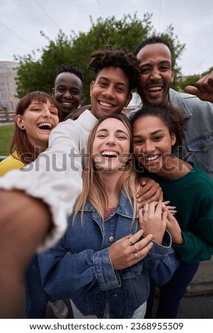 Vertical photo of Cheerful group of friends taking smiling selfie. Group of young people having fun together outdoors at park in the city enjoying travel in vacation holidays. High quality photo