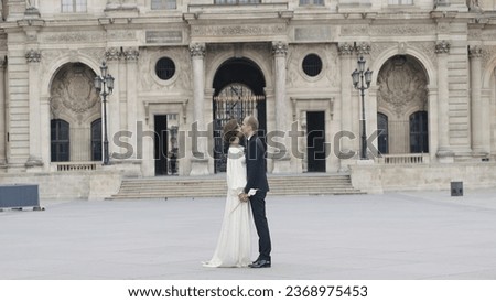 Couple kissing on background of ancient palace. Action. Beautiful view of kissing couple and palace. Couple in elegant outfits kissing in ancient city