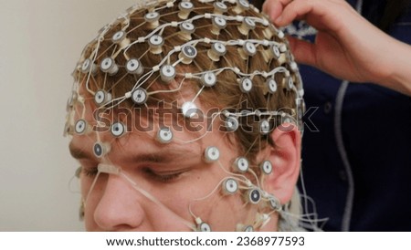 Tests at the hospital. Stock footage. A man to whom new equipment is attached to check the work of the brain.