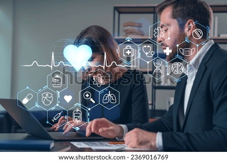 Thoughtful businesspeople typing on laptop at office workplace. Concept of team work, business education, internet surfing, brainstorm, project information technology. Medical healthcare hologram Royalty-Free Stock Photo #2369016769