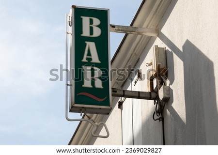 bar sign text board on wall pub facade green with neon arrow