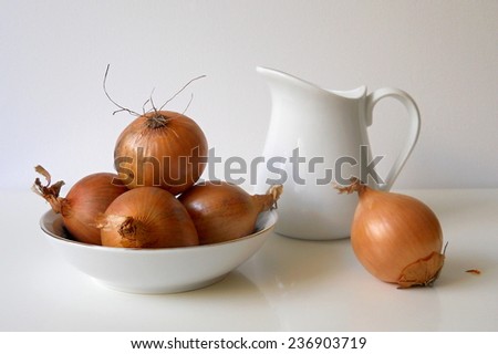 Kitchen still life with brown onions and jug. Kitchen decoration.