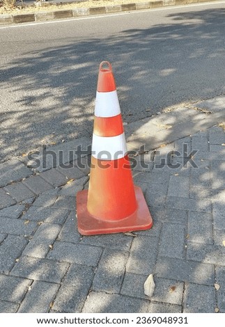 
rural cone on the pedestrian path, above the paved road