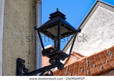 Old town of Slovenian City of Kranj with close-up of black lantern on a sunny summer day. Photo taken August 10th, 2023, Kranj, Slovenia.