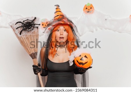 Surprised young woman in halloween costume looking at camera isolated over white background. High quality photo