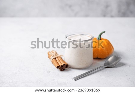 Pumpkin spices coffee creamer in a glass on a white background. toning