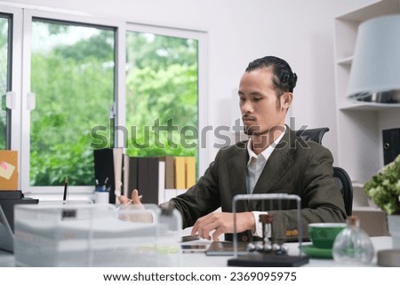 Serious professional business man online working, focused ethnic male student working on laptop, remote studying using computer laptop looking at screen watching seminar webinar at home office.