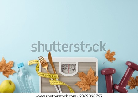 Body refinement in the fall idea. Top view shot of weight scale, dumbbells, fresh apple, tape measure, cutlery, water bottle, dry maple leaves on light blue background with advertising area