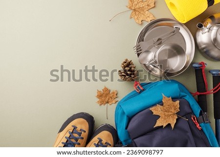 Enhancing your autumnal experience with trekking. Top view shot of metal utensils, trekking poles, hiking rucksack, boots, karemat, fallen leaves on pastel green background with advert area