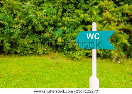 sign indicating the direction to the toilet. toilet in the park. toilet location sign