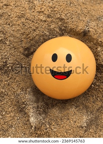Happiness yellow ball on the sand