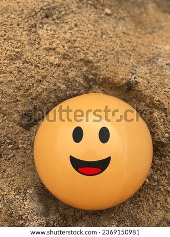 Happiness yellow ball on top the sand