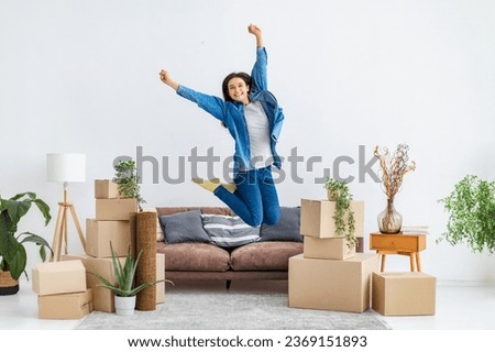 Excited young woman jumping for joy she moved into her new home. New housing, rental concept