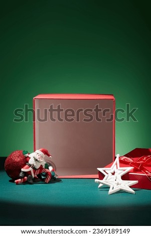 Red gift box with blank space inside for cosmetic or product promotion. Merry christmas concept with some lovely ornaments on dark background