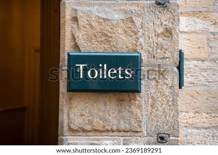 Toilet sign on stone wall. 