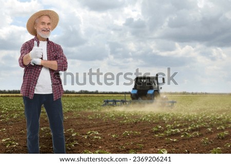 Farmer showing thumbs-up in field. Harvesting season