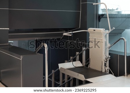 a stair lift for the disabled, wheel chair lift for stairs. Mechanical chair lift taking disabled or aged people up and down stairs. Royalty-Free Stock Photo #2369225295
